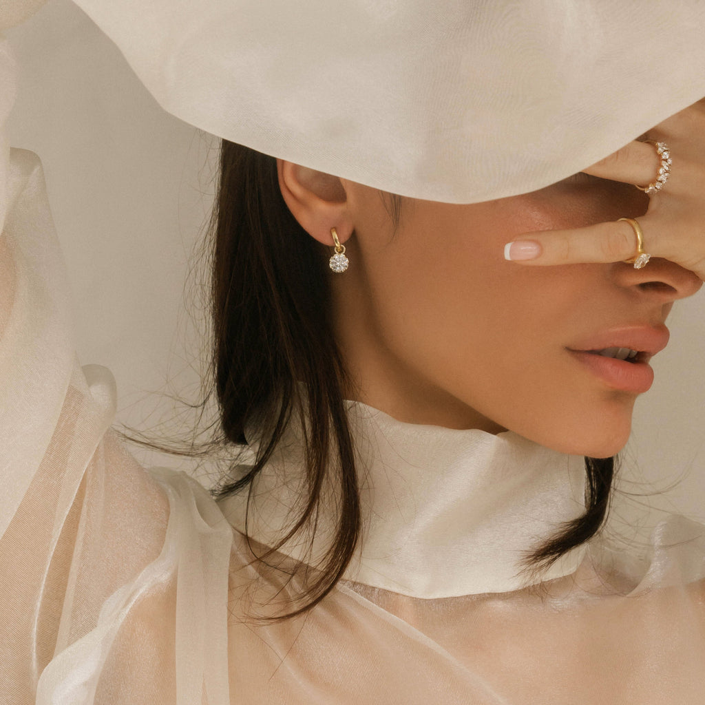 Woman wearing a sheer white garment with a soft focus background