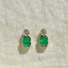 Pair of emerald green square earrings with clear stones on a beige fabric background
