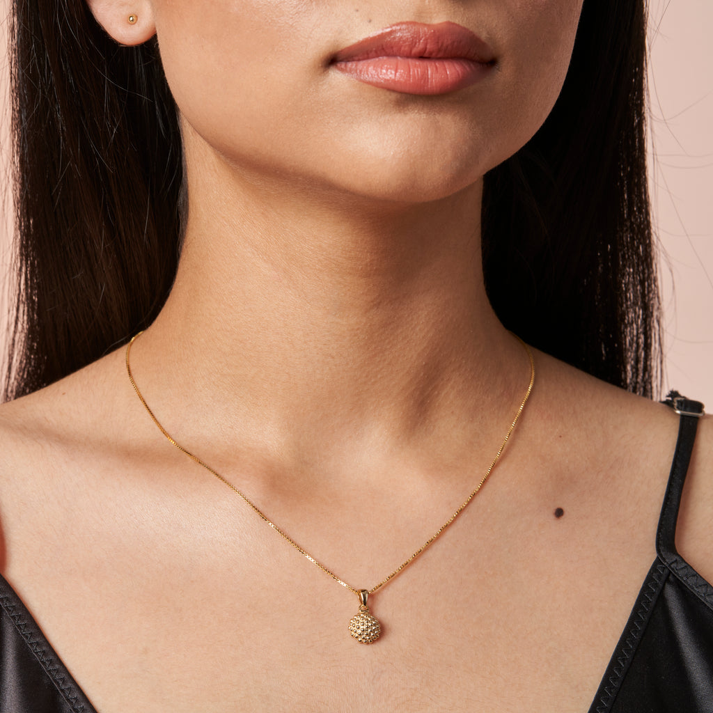 woman wearing Baja Gold Pendant by Ixora Jewelers